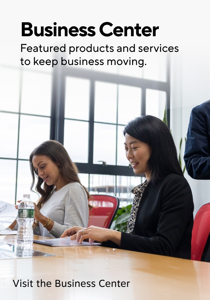 Business Center. Featured products and services to keep business moving. Image shows people seated at a conference table reviewing documents in a modern office with large windows, red chairs, notebooks, and a water bottle. Visit the Business Center.